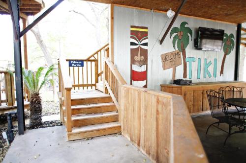 a house with a wooden staircase and a surfboard on the wall at Tiki on the Rio in Third Crossing