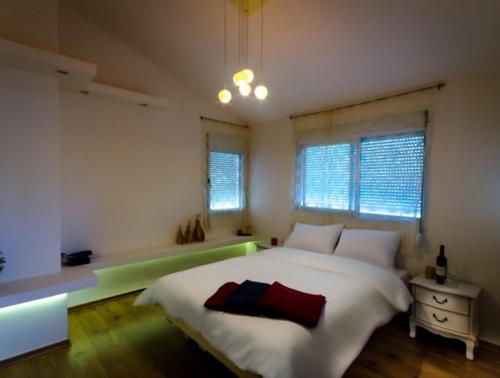 a bedroom with a large white bed and windows at Zimmer In Yuvalim in Yuvallim