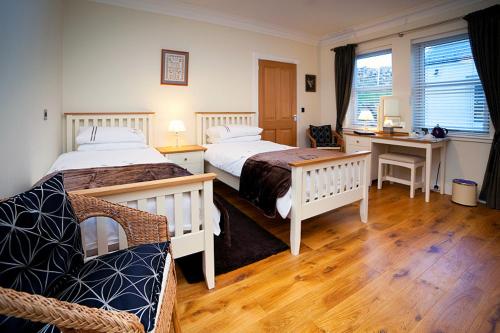 a hotel room with two beds and a desk and a desk at Muldoanich in Gairloch