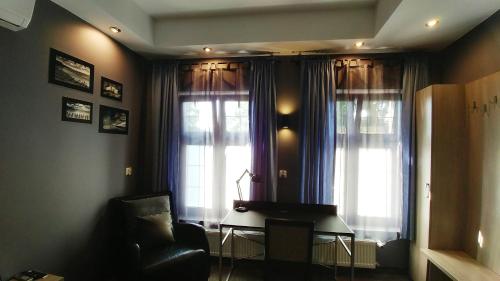 a living room with two windows and a piano at Villa Garden Kutno Centrum in Kutno