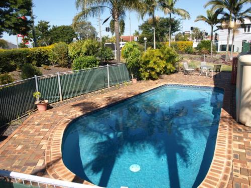 a swimming pool with a shadow of a person standing next to it at Lancaster Court Motel in Brisbane