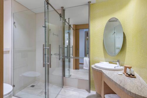 a bathroom with a shower and a sink and a mirror at The Tank Stream Sydney in Sydney