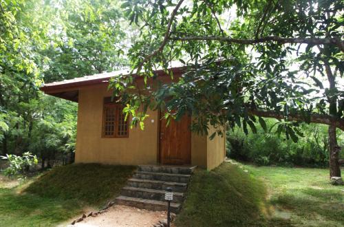 a small house with a door in a yard at Bissa Villa in Habarana