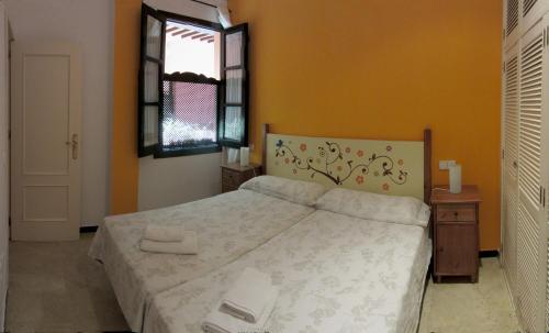 1 dormitorio con cama y ventana en Un Viaje al Pasado en el Centro, en Sevilla