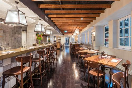 un restaurant avec des tables et des chaises en bois ainsi qu'un bar dans l'établissement The Tank Stream Sydney, à Sydney