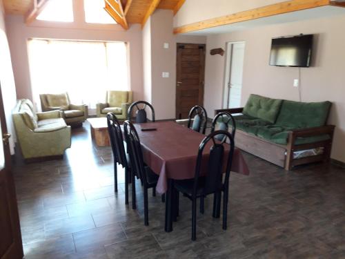 uma sala de estar com uma mesa e cadeiras e um sofá em La Pausa em Villa La Angostura
