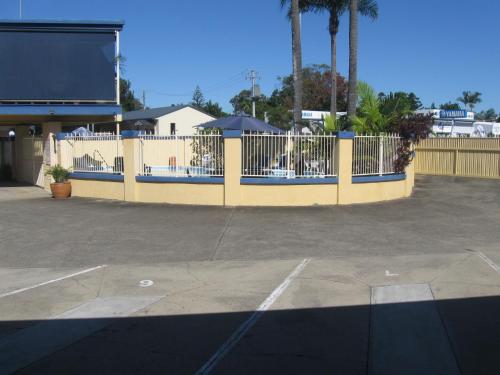 a yellow fence in front of a parking lot at Sunburst Motel in Gold Coast