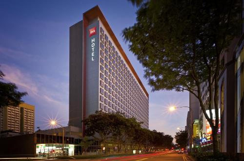 a tall building with a sign on the side of it at Ibis Singapore on Bencoolen - Newly Renovated in Singapore