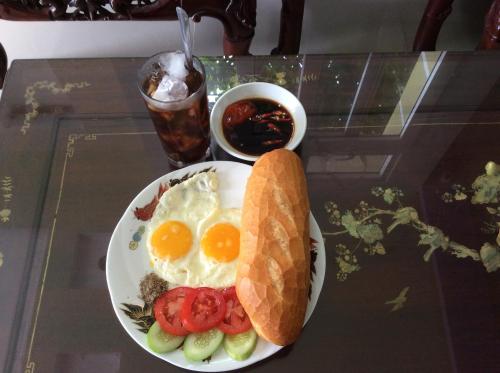 un plato de huevos y pan y una taza de soda en Quoc An Hotel, en Long Hai