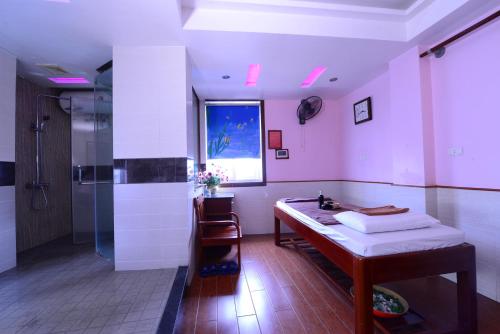 a bathroom with a table and a shower and a sink at Blue Hanoi Inn Luxury Hotel in Hanoi