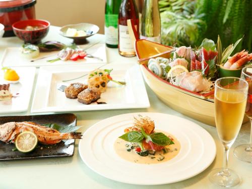 a table with plates of food and a glass of wine at Koibito Misaki Pension Marine Mates in Izu