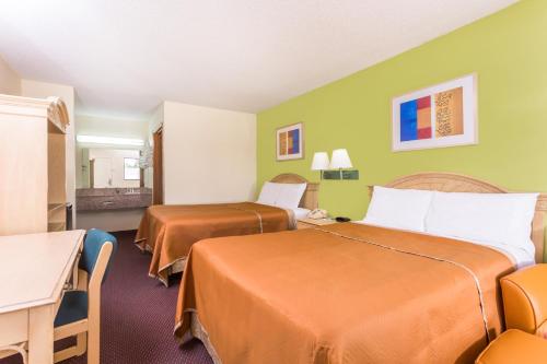 ein Hotelzimmer mit 2 Betten, einem Tisch und Stühlen in der Unterkunft Travelodge by Wyndham Cordele in Cordele