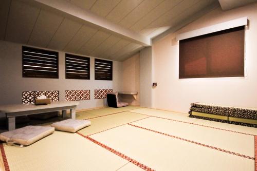 a room with a flat screen tv and a table at The Tiles Garden Yilan B&B in Dongshan