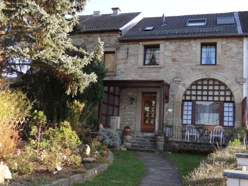 a stone house with a pathway leading to the front door at Gästehaus Burg Molbach in Kreuzau