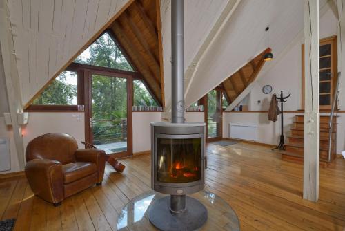 a living room with a fireplace in a house at la maison dans les bois in Soucelles