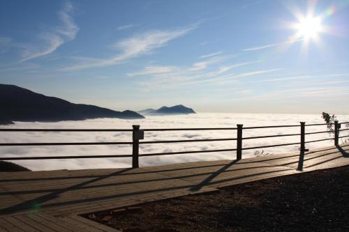 a fence with the sun in the sky over the ocean at 深山林內民宿 in Zhushan