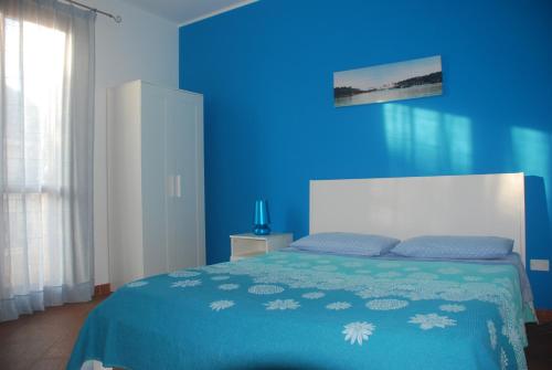 a blue bedroom with a bed and a blue wall at Eolo in Marsala