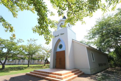 a small white church with a wooden door at Tsushima Grand Hotel in Tsushima