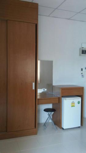 a kitchen with a wooden desk and a refrigerator at Noble U-house Chiangmai in Chiang Mai