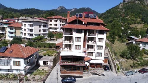 un gran edificio con techo rojo en una ciudad en Hotel Uzunski en Smolyan