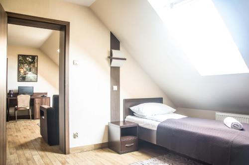 a attic bedroom with a bed and a desk at Hotel Mieszko in Rzeszów