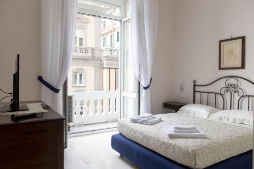 a bedroom with a bed and a large window at Casa San Carlo in Naples