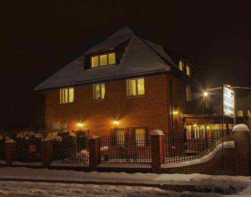 a house with a fence in the snow at night at Dom Gościnny 8 km od Suntago, Deepspot in Radziejowice