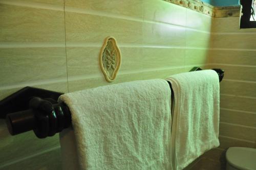 a bathroom with two towels hanging on a wall at La Veranda Di Serena in Unawatuna