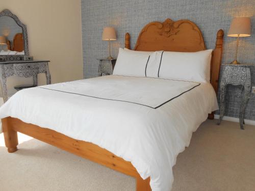 a bedroom with a large bed with white sheets and pillows at Luxury 4 Bed 3 Bathroom Bungalow , South West of London, The Dapples in Epsom