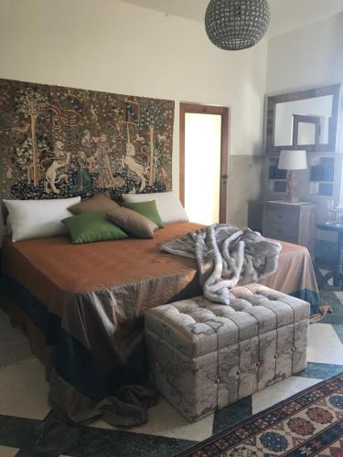 a bedroom with a large bed and a couch at Villa Ottolenghi Wedekind in Acqui Terme