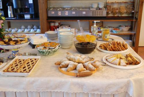 a table topped with plates of food and pastries at Hotel Valdor in Cavallino-Treporti