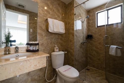 a bathroom with a toilet and a sink and a shower at Asian Ruby Center Point Hotel & Spa in Ho Chi Minh City
