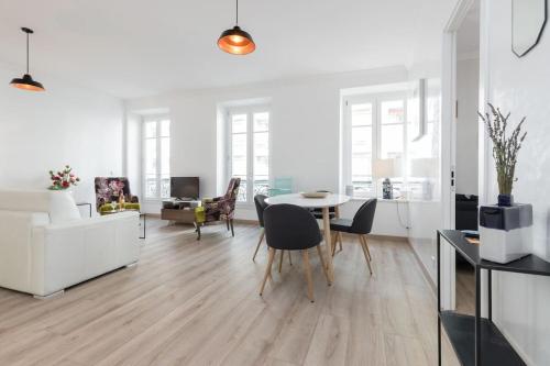 a white living room with a table and chairs at Holiday apartment - Nice in Nice