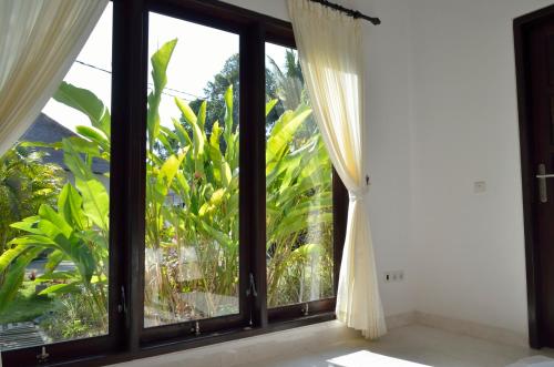 a window with a view of a garden at Villa Danison in Umeanyar