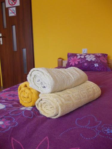 a pile of towels sitting on top of a bed at Pokoje Gościnne "U Karola" Pracownicze in Ścinawa