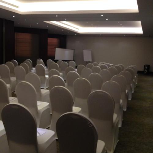 an empty room with white chairs and a screen at Executives Hotel - Azizia in Riyadh