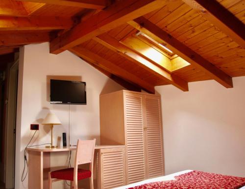 a bedroom with a bed and a desk and a tv at Santanna in Verbania