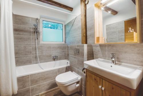 La salle de bains est pourvue de toilettes, d'un lavabo et d'une douche. dans l'établissement Alpenhaus Monte, à Neustift im Stubaital