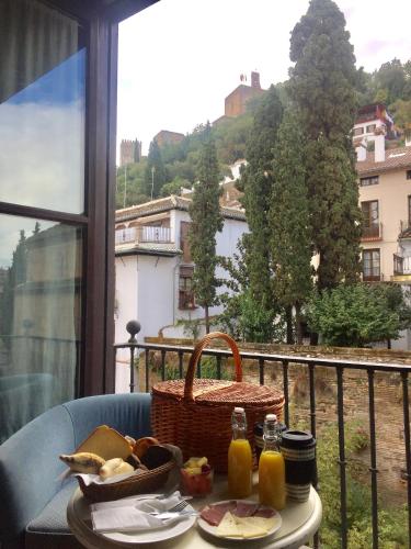 グラナダにあるパラシオ デ マリアナ ピネダのバルコニーにテーブルと食べ物のバスケット