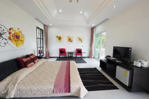 a bedroom with a bed and a flat screen tv at Baan Ing Khao in Pak Chong