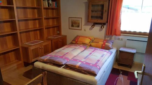 een kleine slaapkamer met een bed en houten kasten bij Ferienwohnungen Felder in Schruns