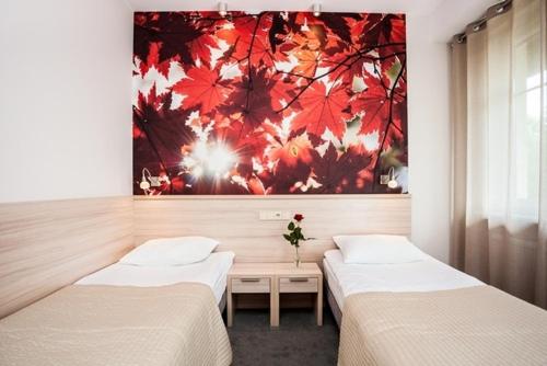 2 camas en una habitación con un cuadro en la pared en Hotel Nosselia, en Krzyczki