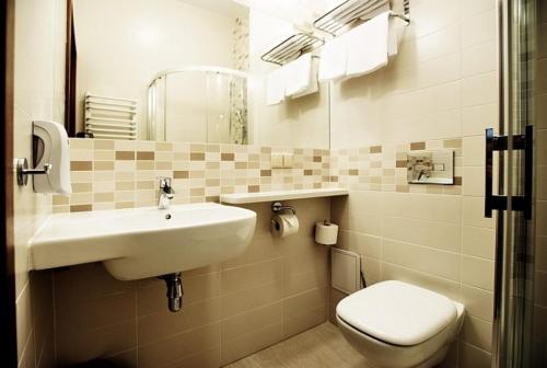 La salle de bains est pourvue d'un lavabo et de toilettes. dans l'établissement Hotel Nosselia, à Krzyczki