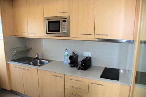 uma cozinha com um lavatório e um micro-ondas em Studio Estádio do Dragão no Porto