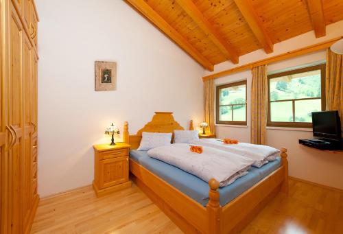 um quarto com uma cama e uma televisão em Ferienhaus Hochkönig em Dienten am Hochkönig