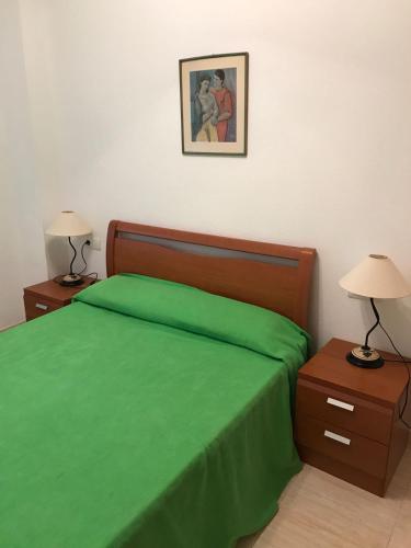 a bedroom with a green bed with two night stands at Apartamento en Oropesa del Mar in Oropesa del Mar