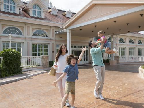 a family playing in front of a house at Gardaland Hotel in Castelnuovo del Garda