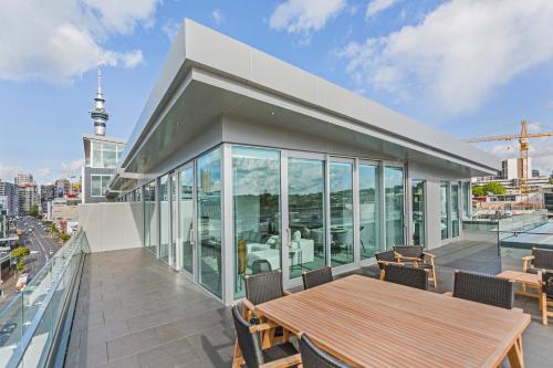 a building with a table and chairs on a balcony at Swiss-Belsuites Victoria Park Auckland in Auckland