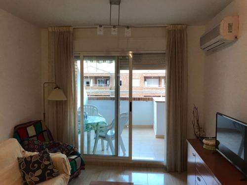 a living room with a sliding glass door to a patio at Apartamento en Oropesa del Mar in Oropesa del Mar