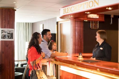 a group of people standing around a bar at Hotel Savoy in Mariehamn